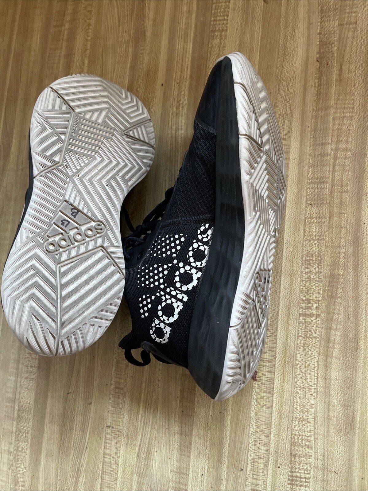adidas lightmotion size 11 black and white athletic shoes with patterned soles on wooden floor