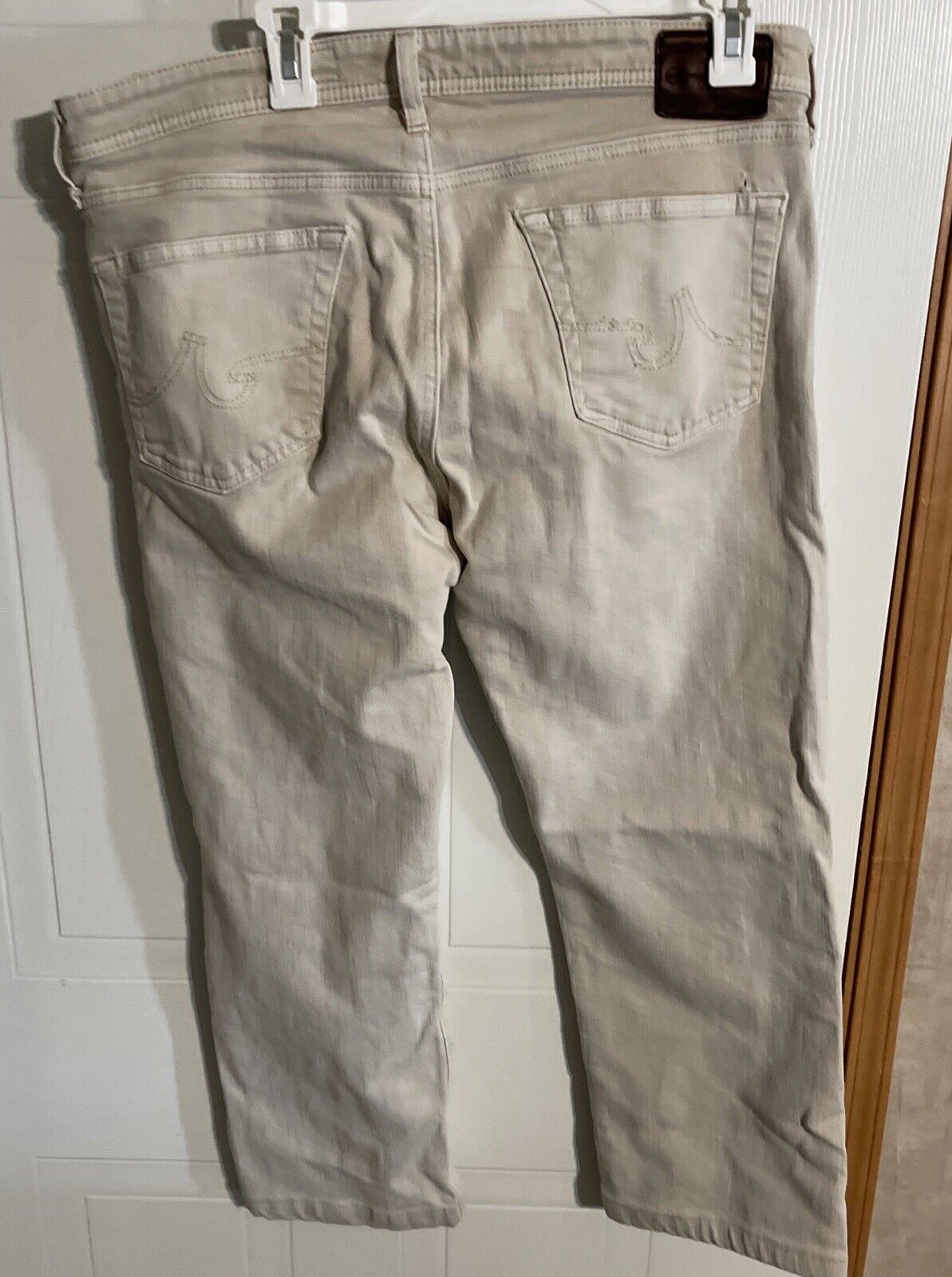 Beige Adriano Goldschmied Matchbox jeans hanging with visible back pockets and leather brand patch