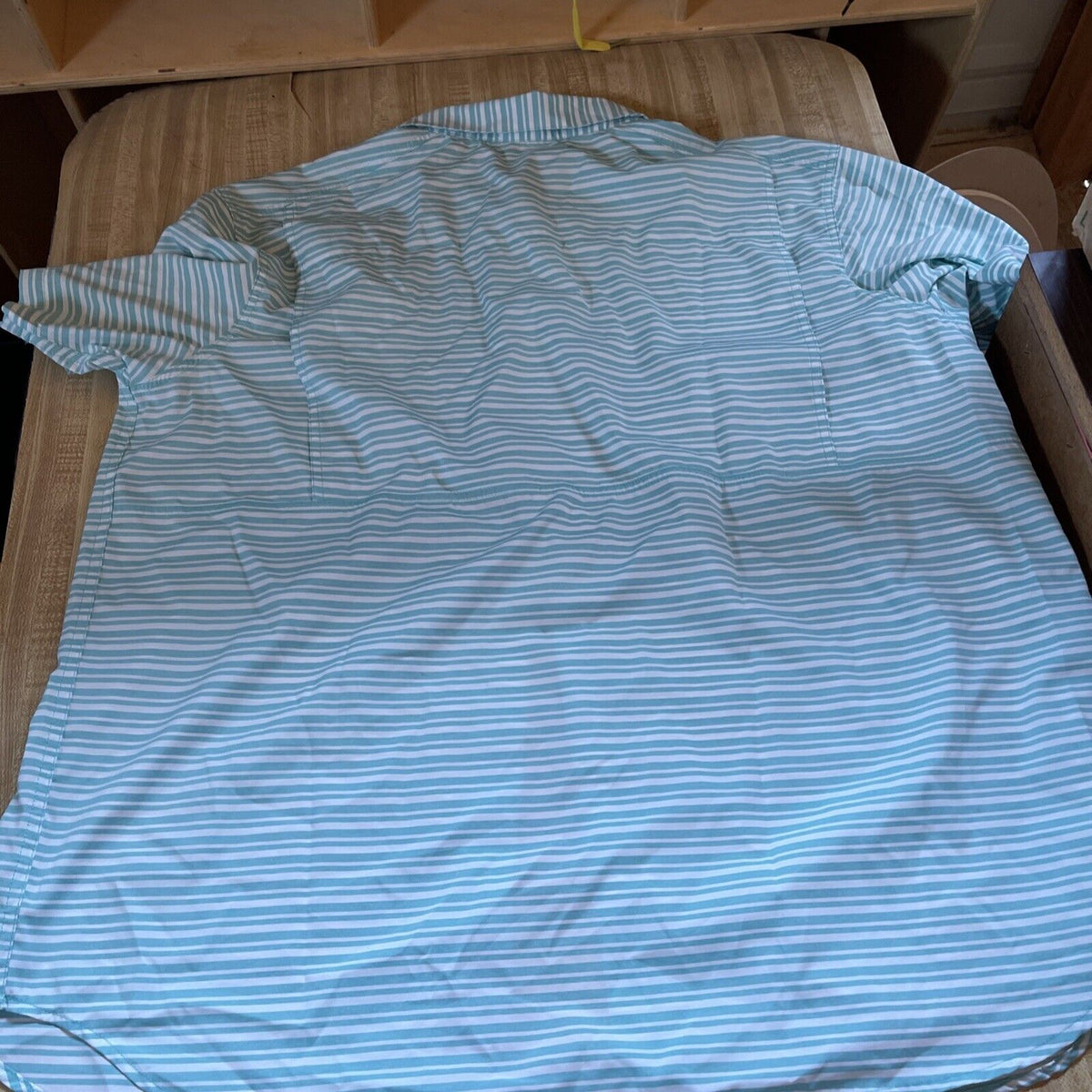 Light blue and white striped Columbia vented shirt XXL laid flat on a couch showing back side