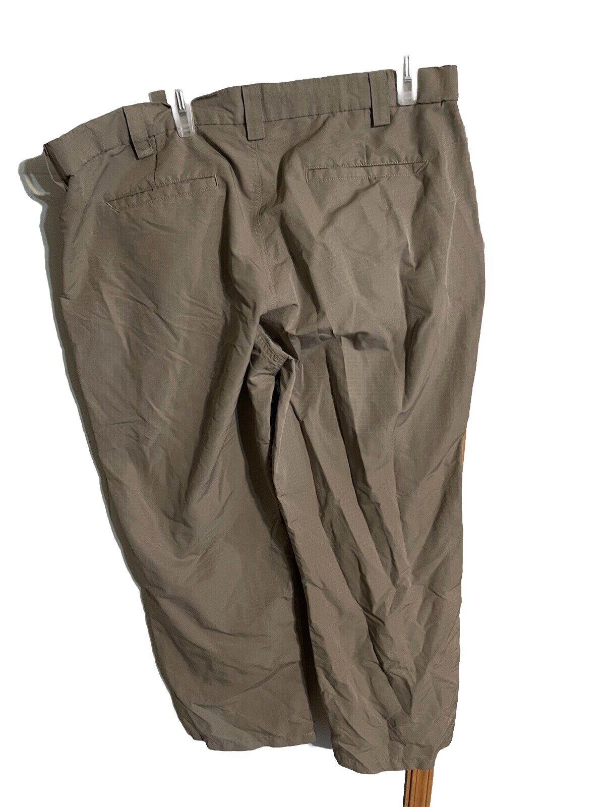 Men's outdoor pants 40x30 in brown with belt loops and back pockets hanging on clips