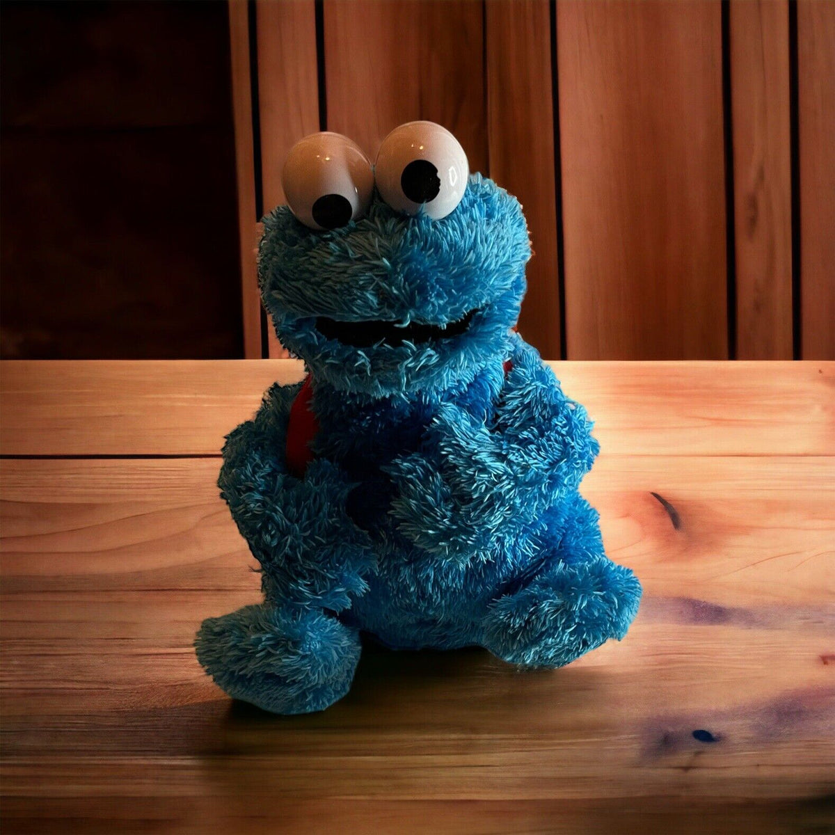 Blue Cookie Monster Sesame Street collectible plush sitting on wooden surface with large eyes
