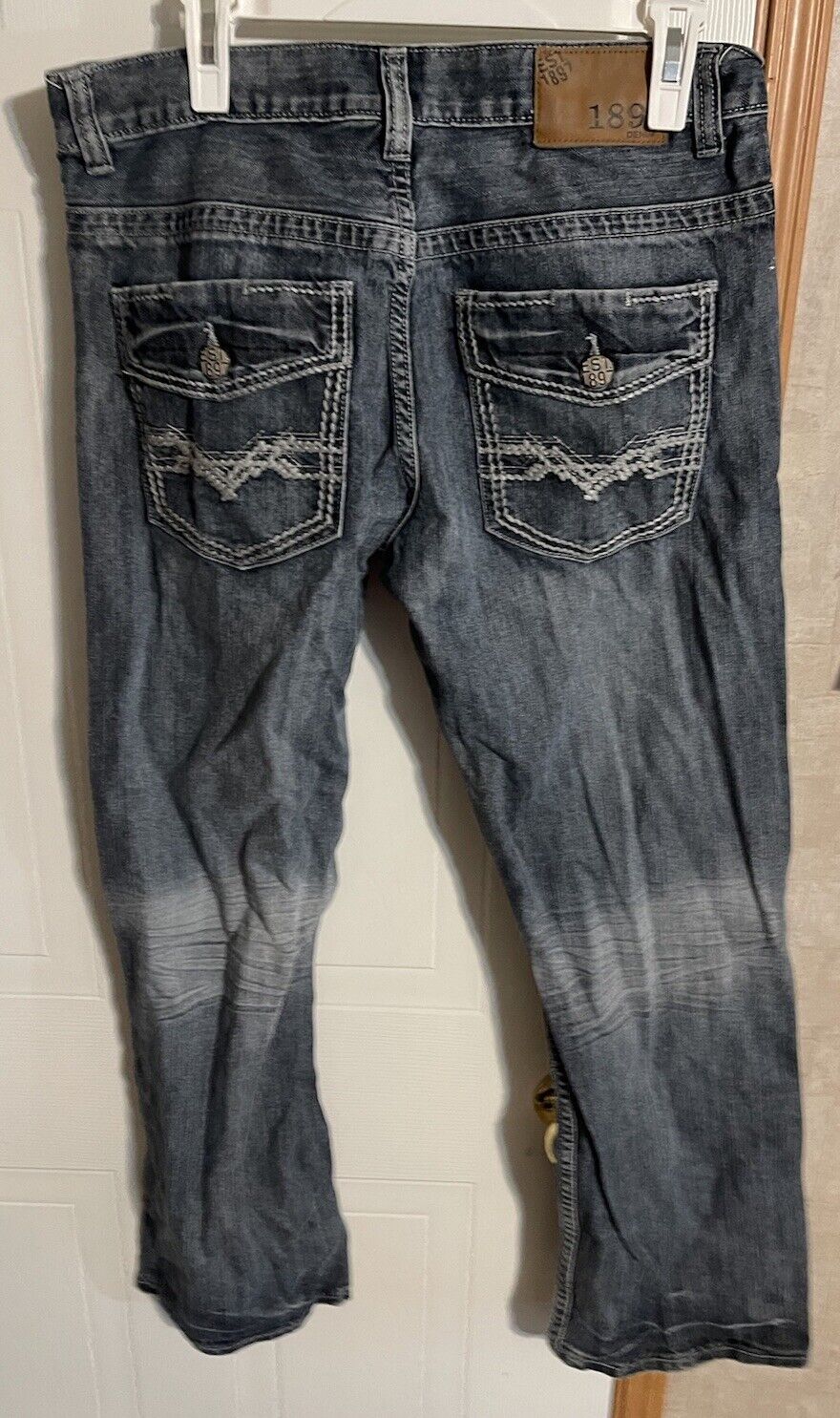 Back view of 1897 jeans for men in faded black denim with detailed back pockets and button closures