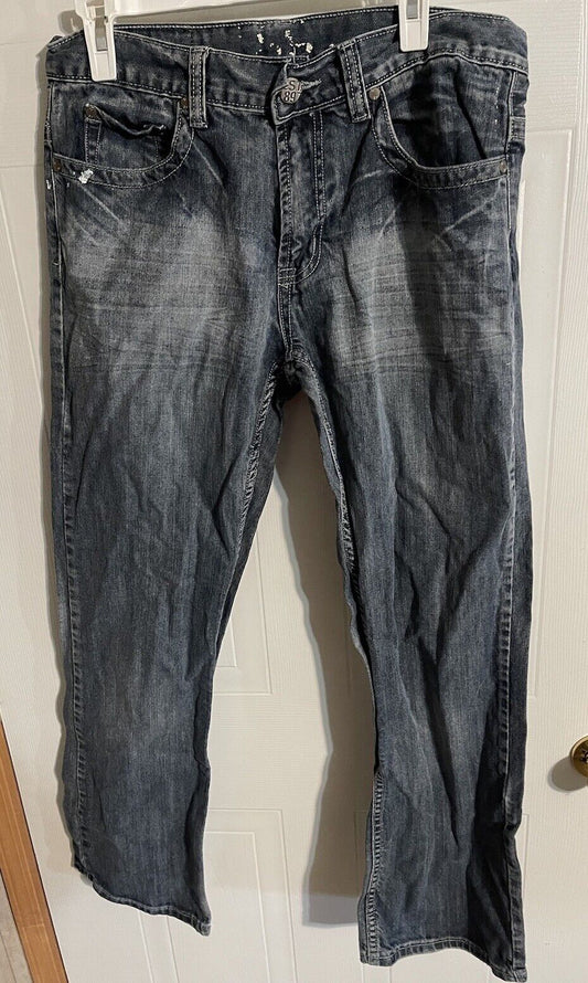 Faded black 1897 jeans for men with front pockets and belt loops hanging on a white door