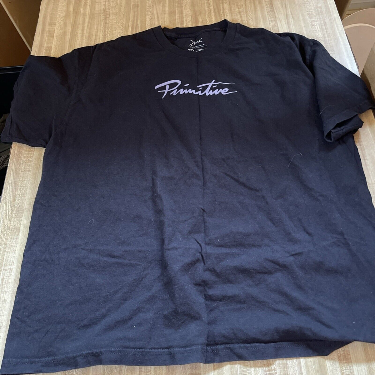Black 2pac Primitive T Shirt with white Primitive logo across the chest by 1118 Emporium