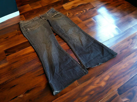 Faded black 575 Brand women's jeans with a bootcut fit laid on wooden floor