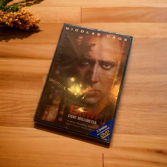 8MM DVD 1999 movie featuring Nicolas Cage in original plastic case on wooden surface