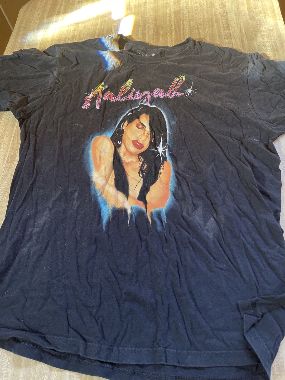 Black Aaliyah graphic t shirt featuring a colorful portrait of Aaliyah with her name in stylized text