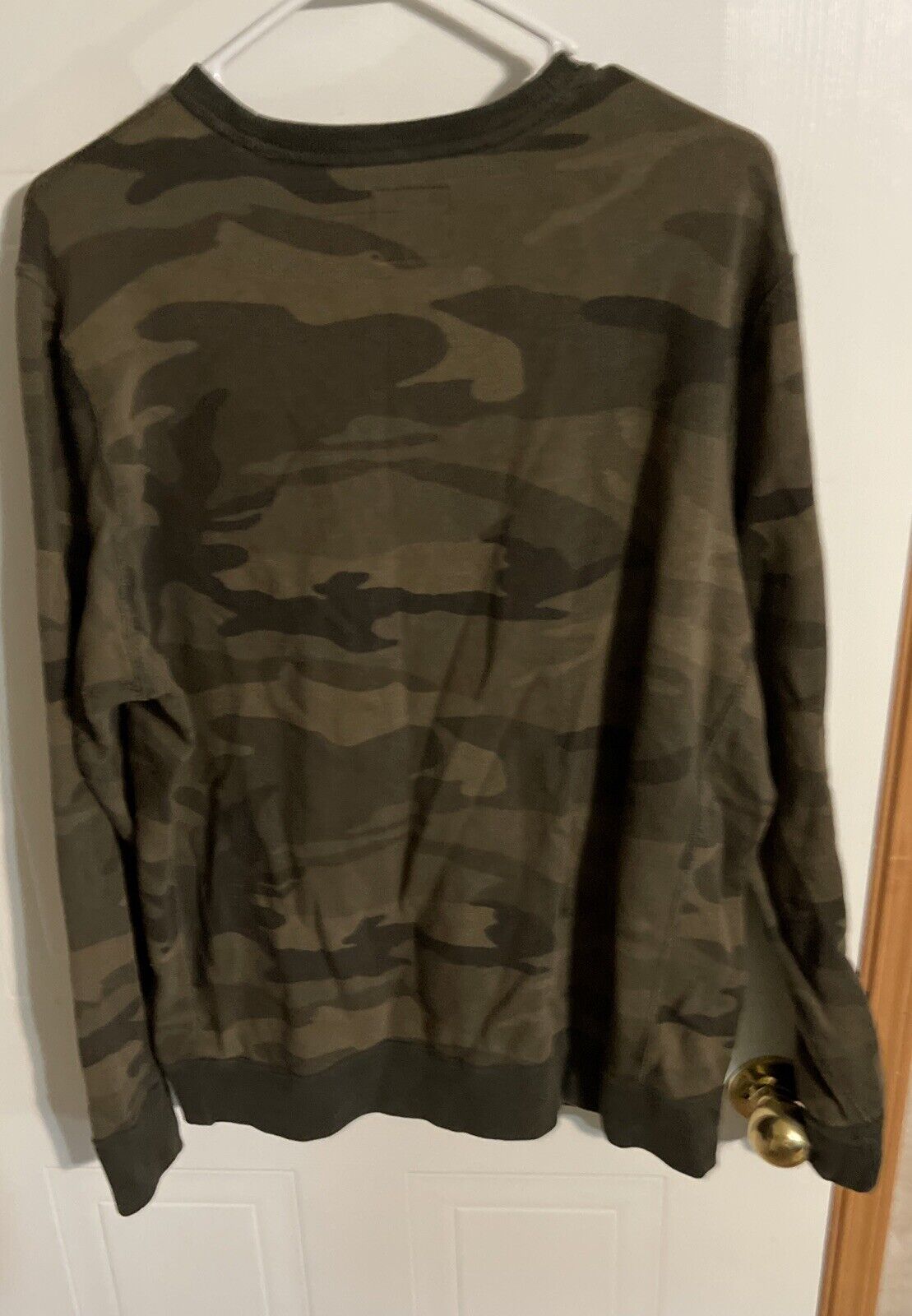Abercrombie Fitch camo sweatshirt hanging on white hanger with green and brown camouflage pattern