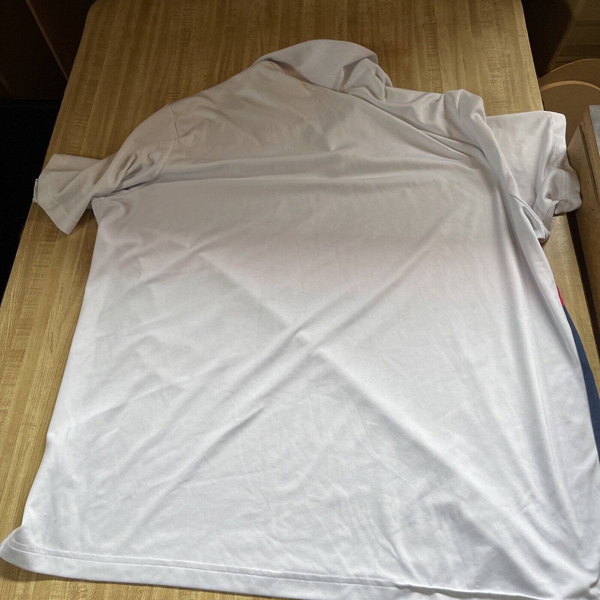 Adidas Climacool Polo 2XL laid flat on wooden surface showing back side