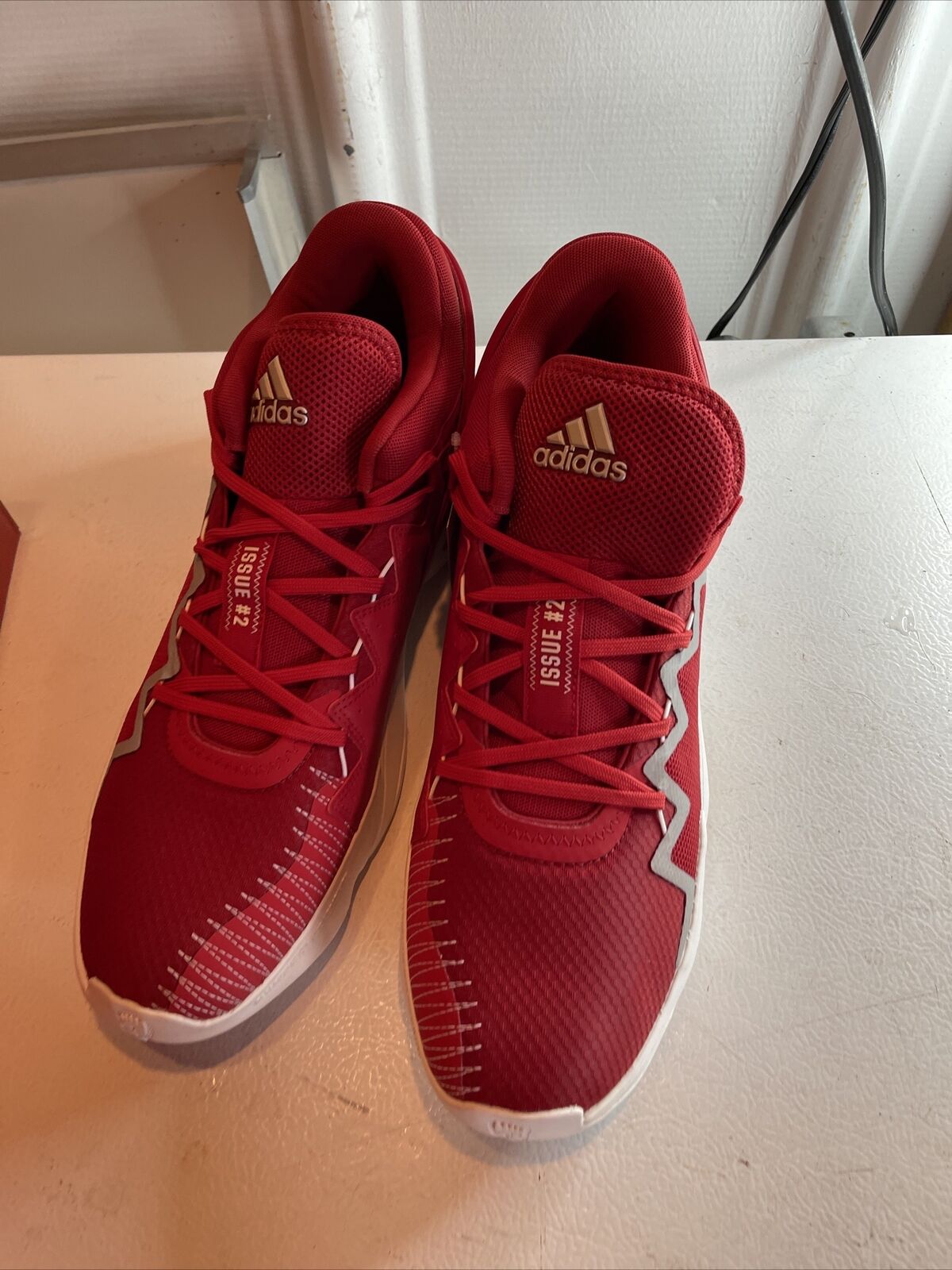 Men's red adidas basketball shoes with lace-up design and cushioned soles for performance