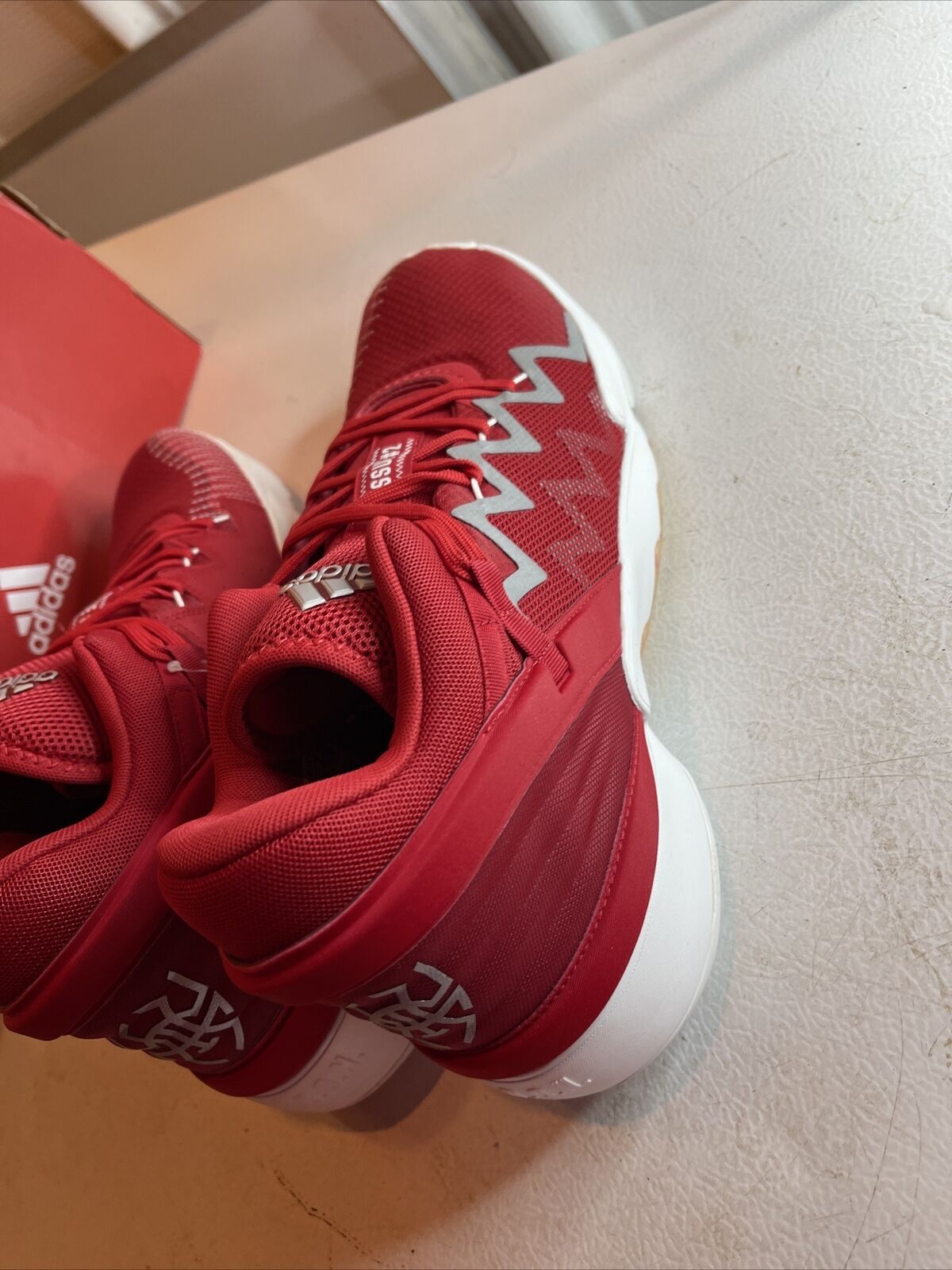 Men's red adidas basketball shoes with white sole and zigzag design on sides