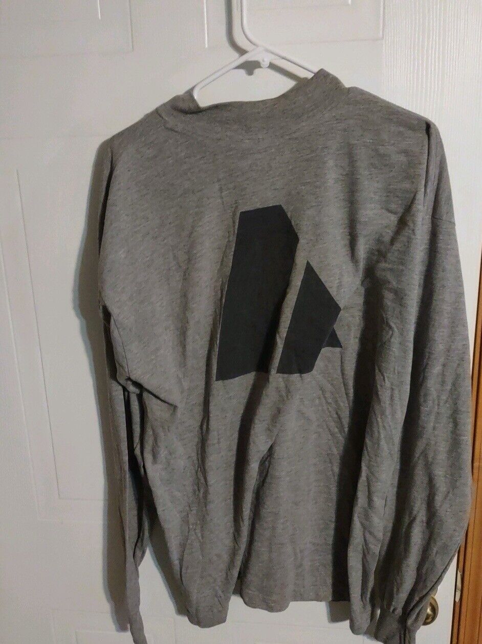 Gray long sleeve AKWA Tek army shirt with black geometric design on back hanging on white hanger