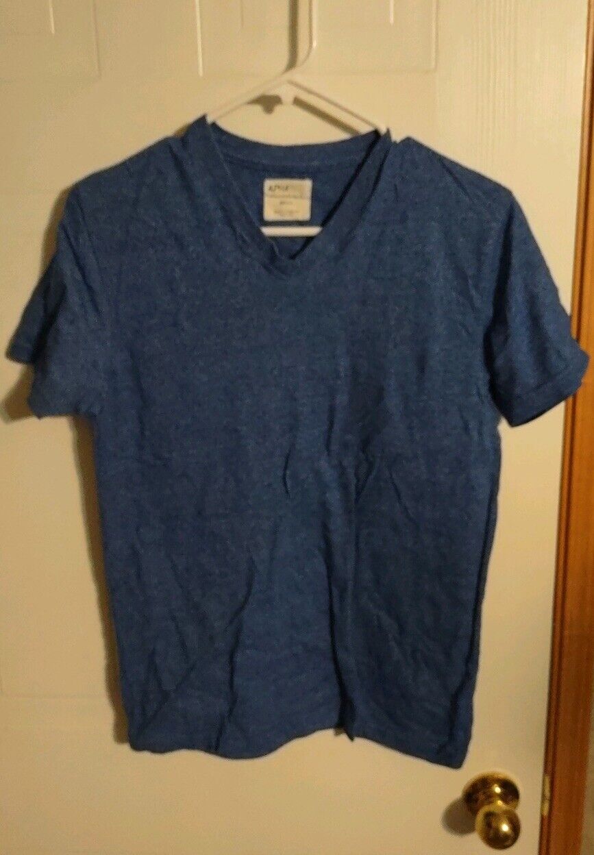 Alphabeta blue t-shirt small hanging on hanger against a beige door background
