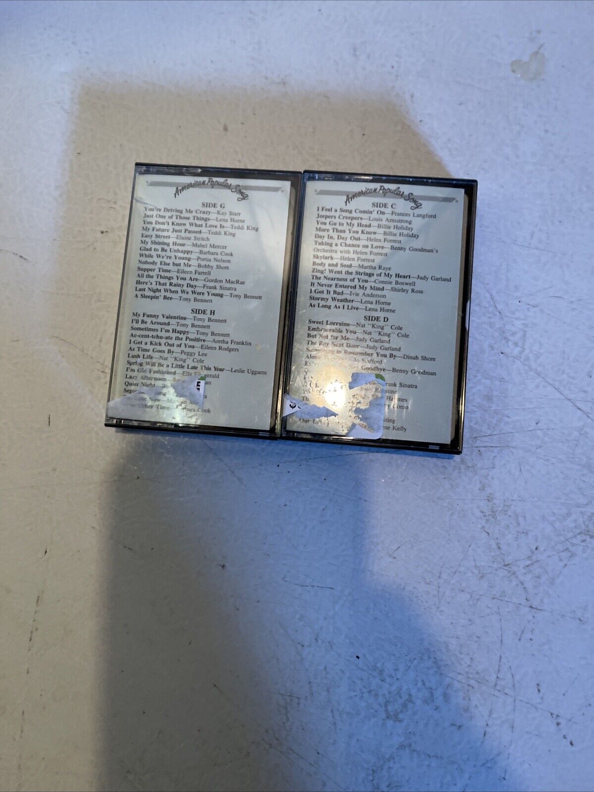 Two vintage cassette tapes with American popular song cassette lot text on worn labels from 1118 Emporium