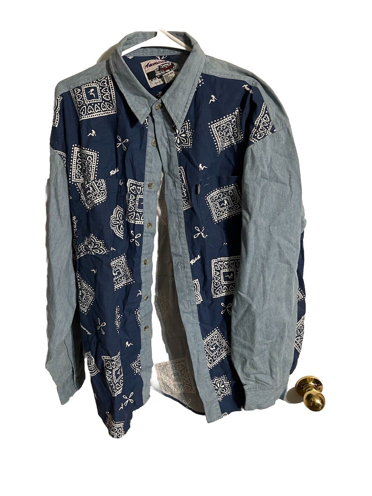 American Rebel western shirt with blue patterned front and light denim sleeves hanging on a hanger