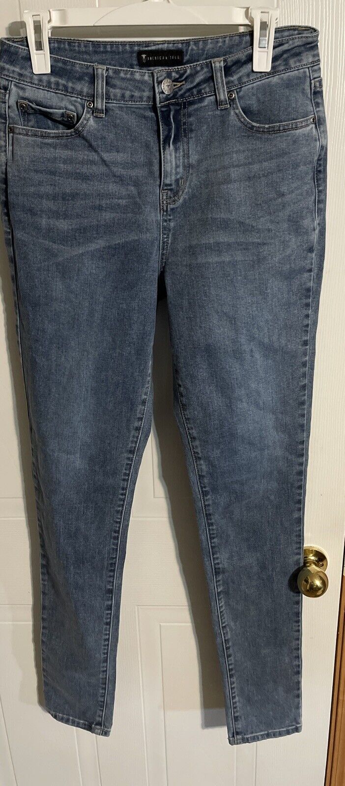 American Tall denim jeans in classic blue wash hanging on white hanger