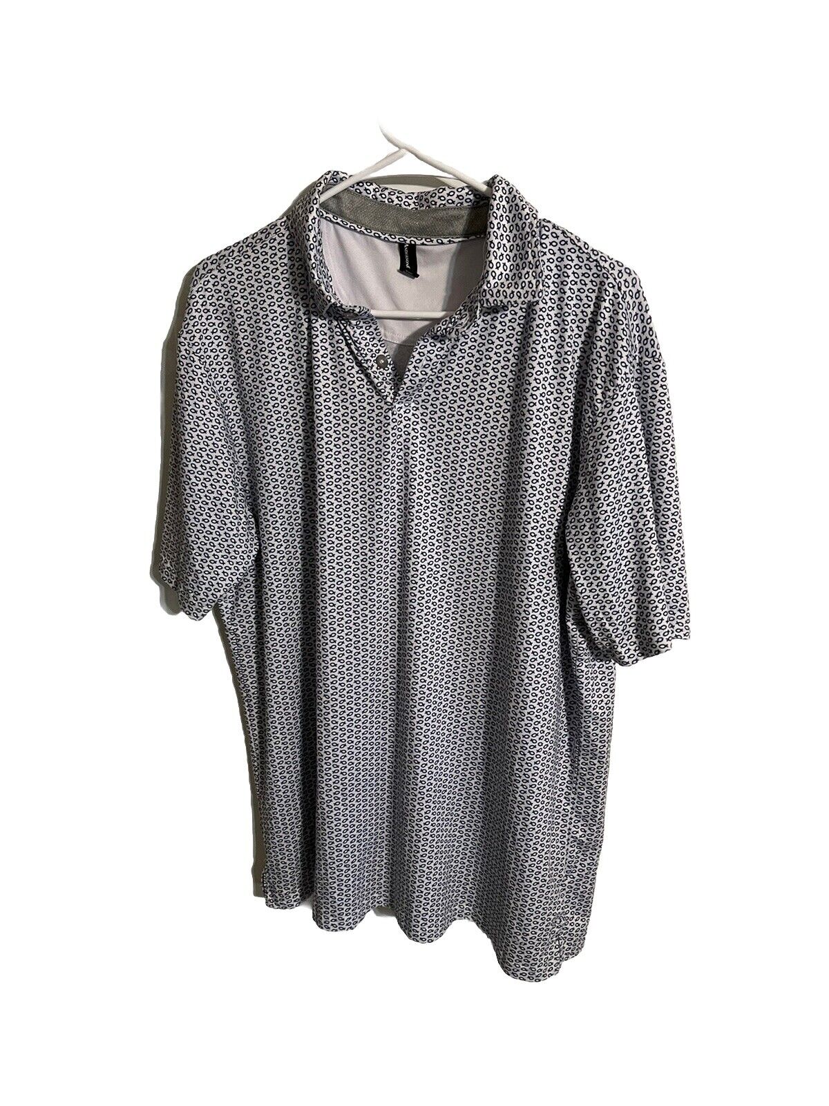 Anderson Ord golf polo with black and white geometric pattern hanging on white hanger