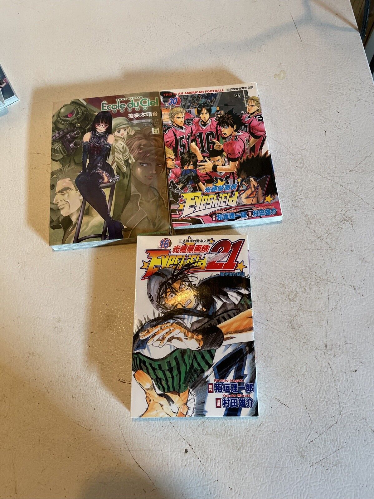 Anime book lot for sale featuring three manga volumes with colorful covers on a white surface