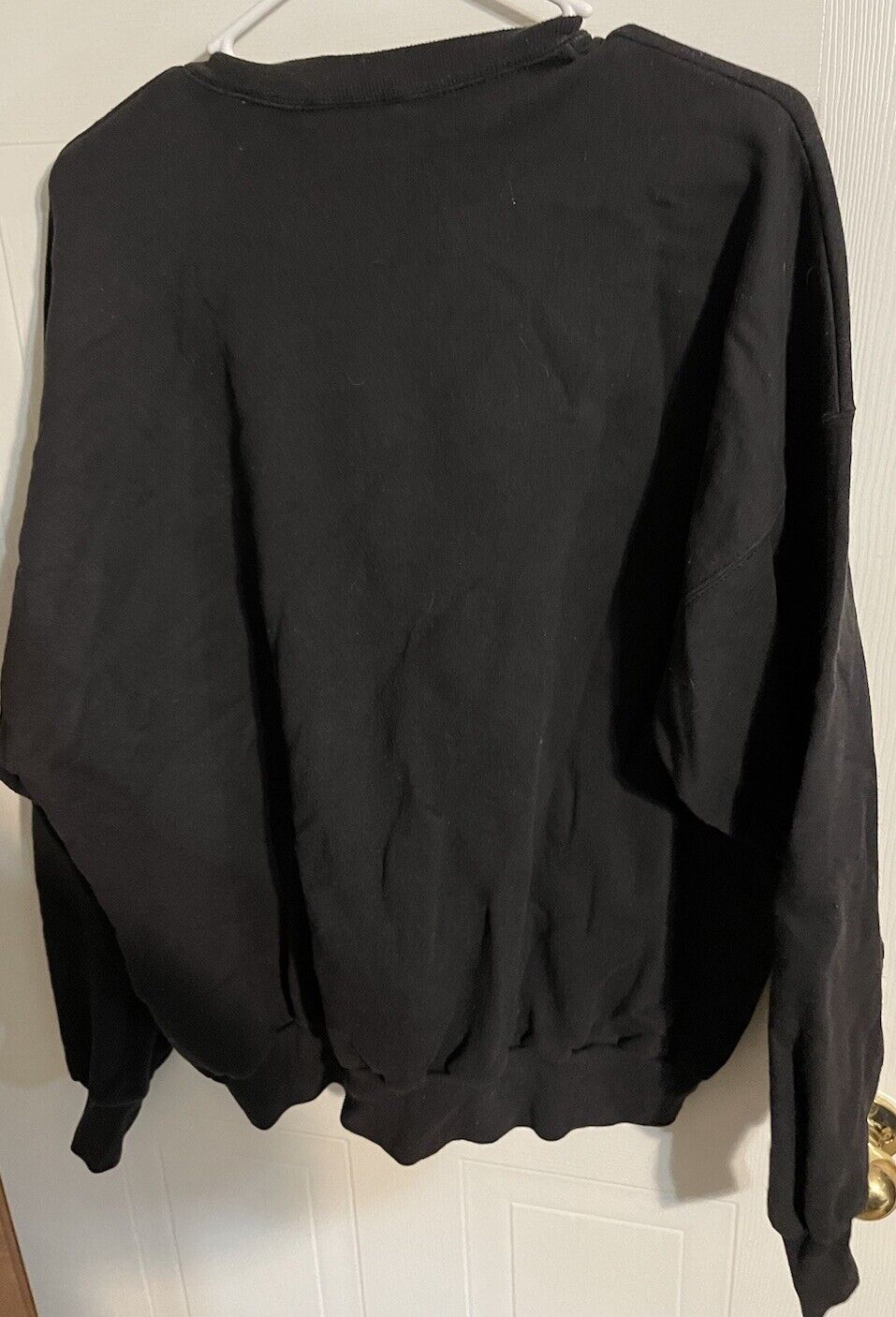Black Arctic Circle sweatshirt XXL hanging on white hanger against door background