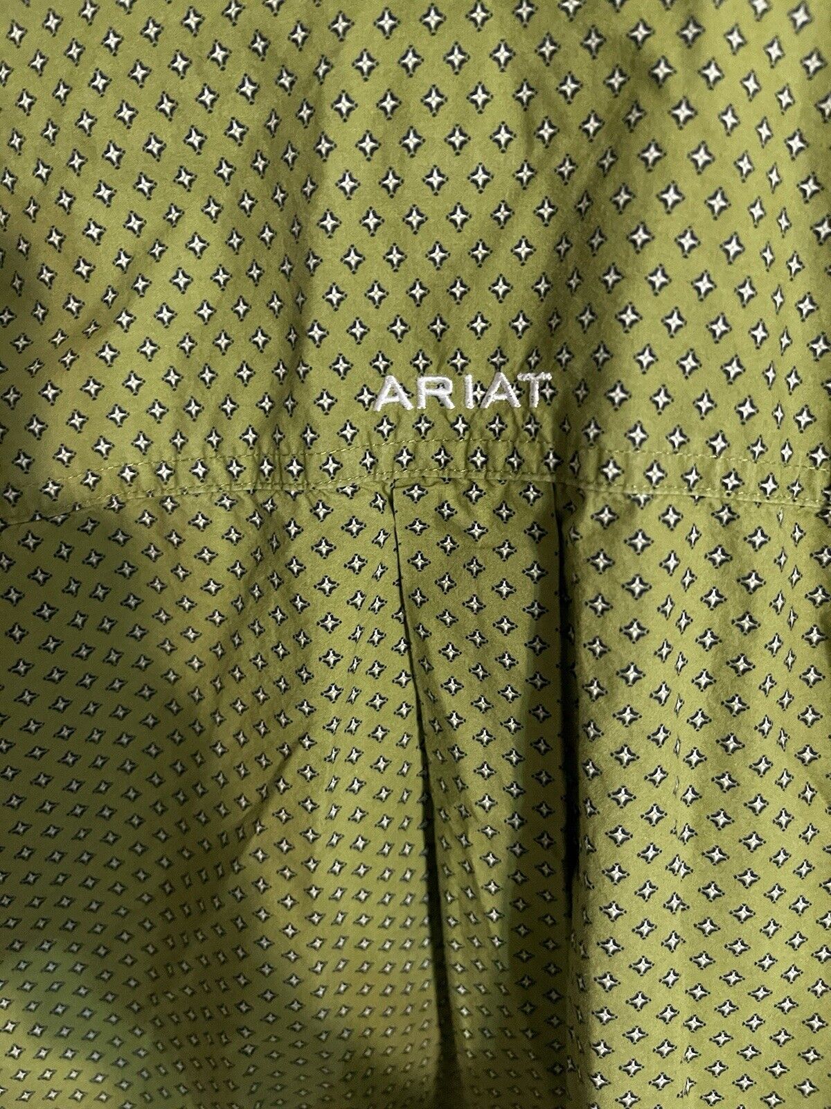 Close-up of green patterned fabric with Ariat logo on Ariat men's medium shirt