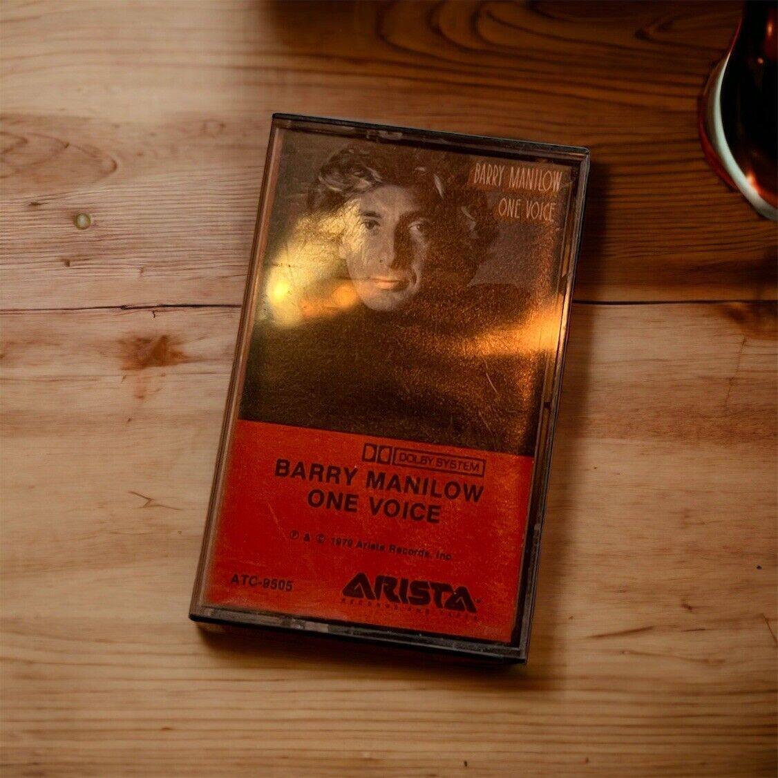 Barry Manilow One Voice cassette tape with red and black cover on wooden surface