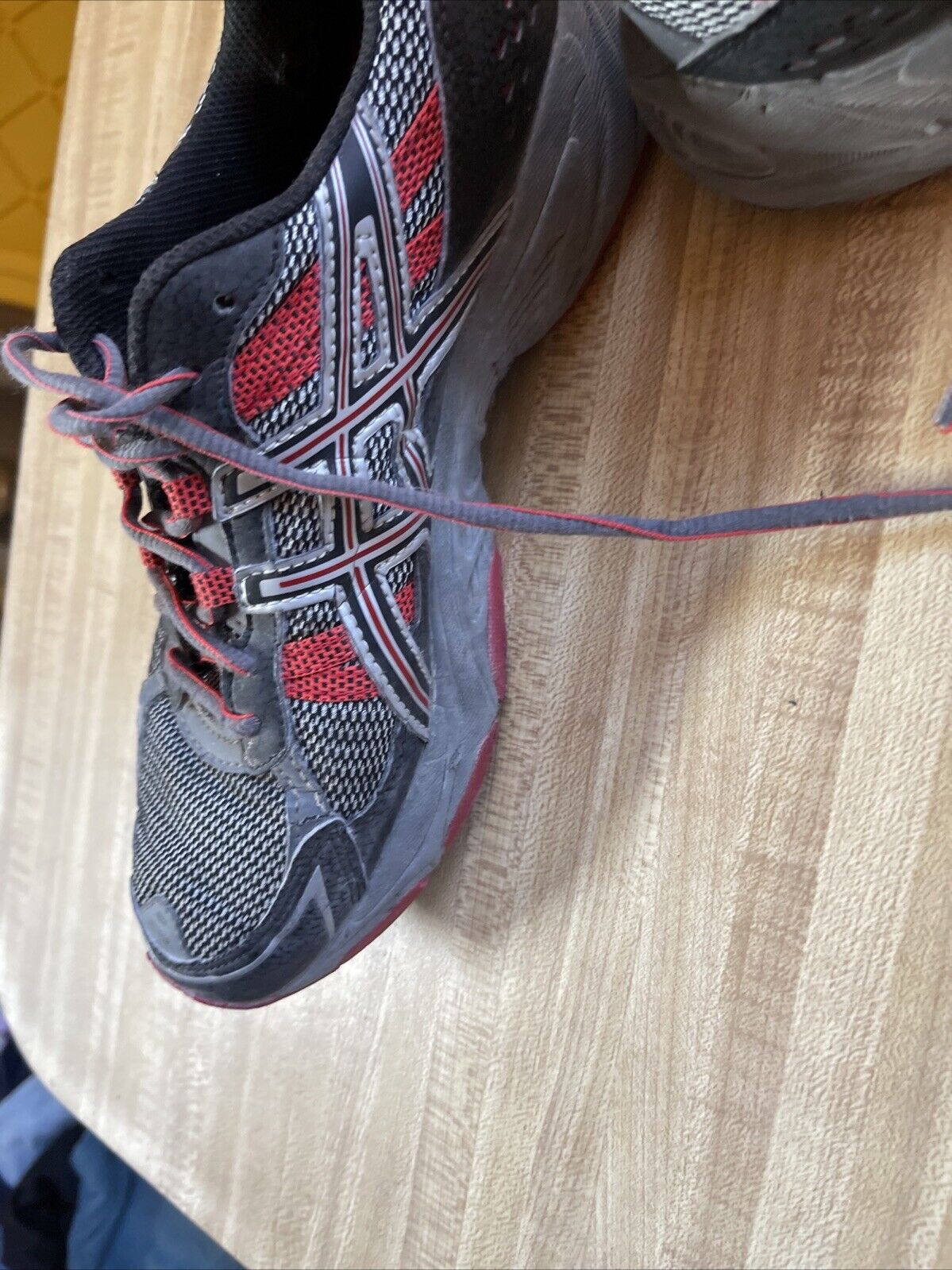 ASICS Gel Venture 4 men’s size 12 black and red running shoes on wooden surface