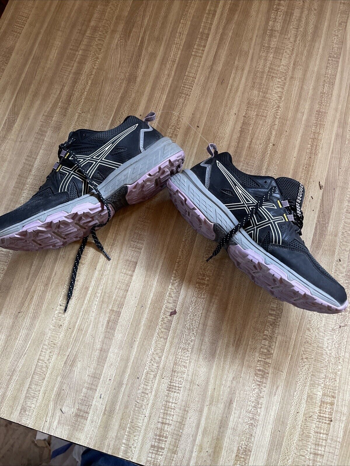ASICS Gel Venture 8 women’s wide black athletic shoes with pink soles displayed on wooden floor
