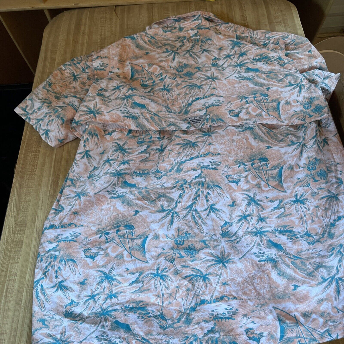 Columbia vented fishing shirt XXL in tropical print with palm trees and sailboats, laid flat on bed