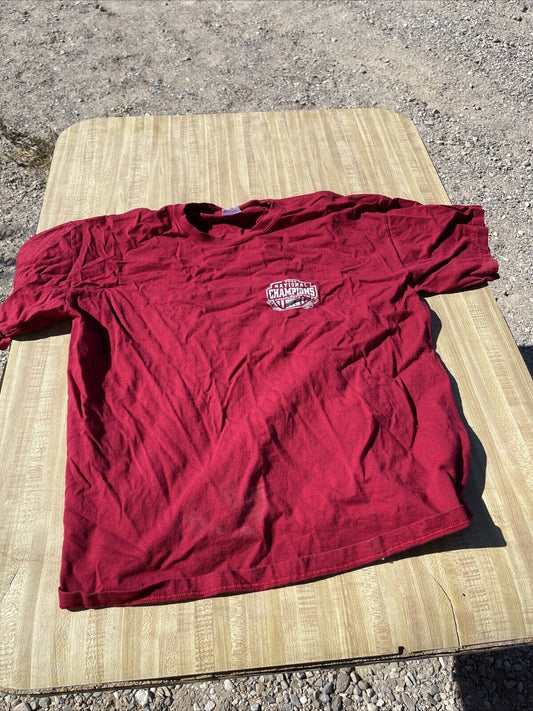 Men's 2009 Alabama champion apparel red t-shirt with championship logo on front laid flat on wooden table