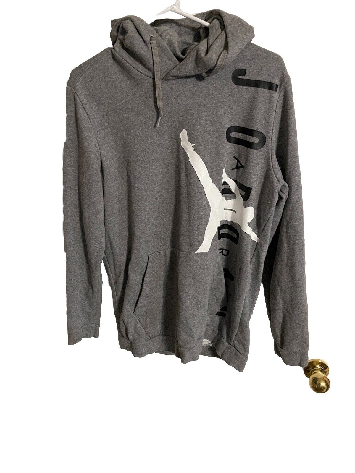 Gray Air Jordan jogger set hoodie with black and white logo design hanging on hanger