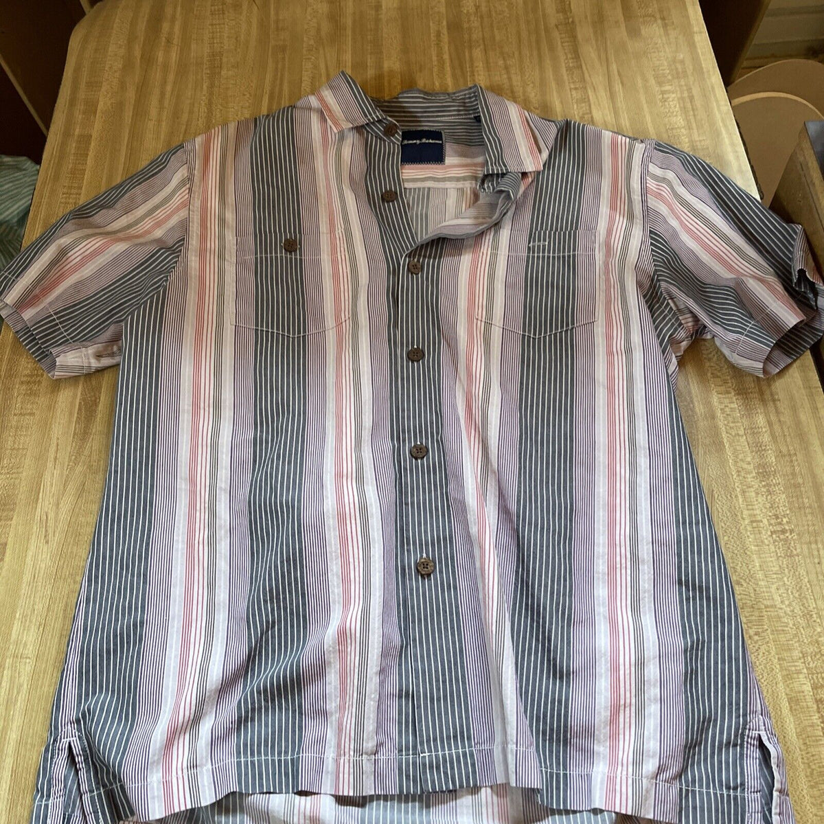 Tommy Bahama silk blend shirt with vertical striped pattern in muted colors on wooden surface