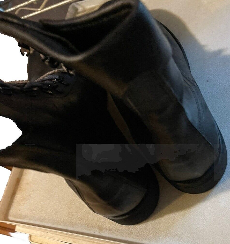 Pair of black vintage Addison combat boots showing back and side views on a beige surface