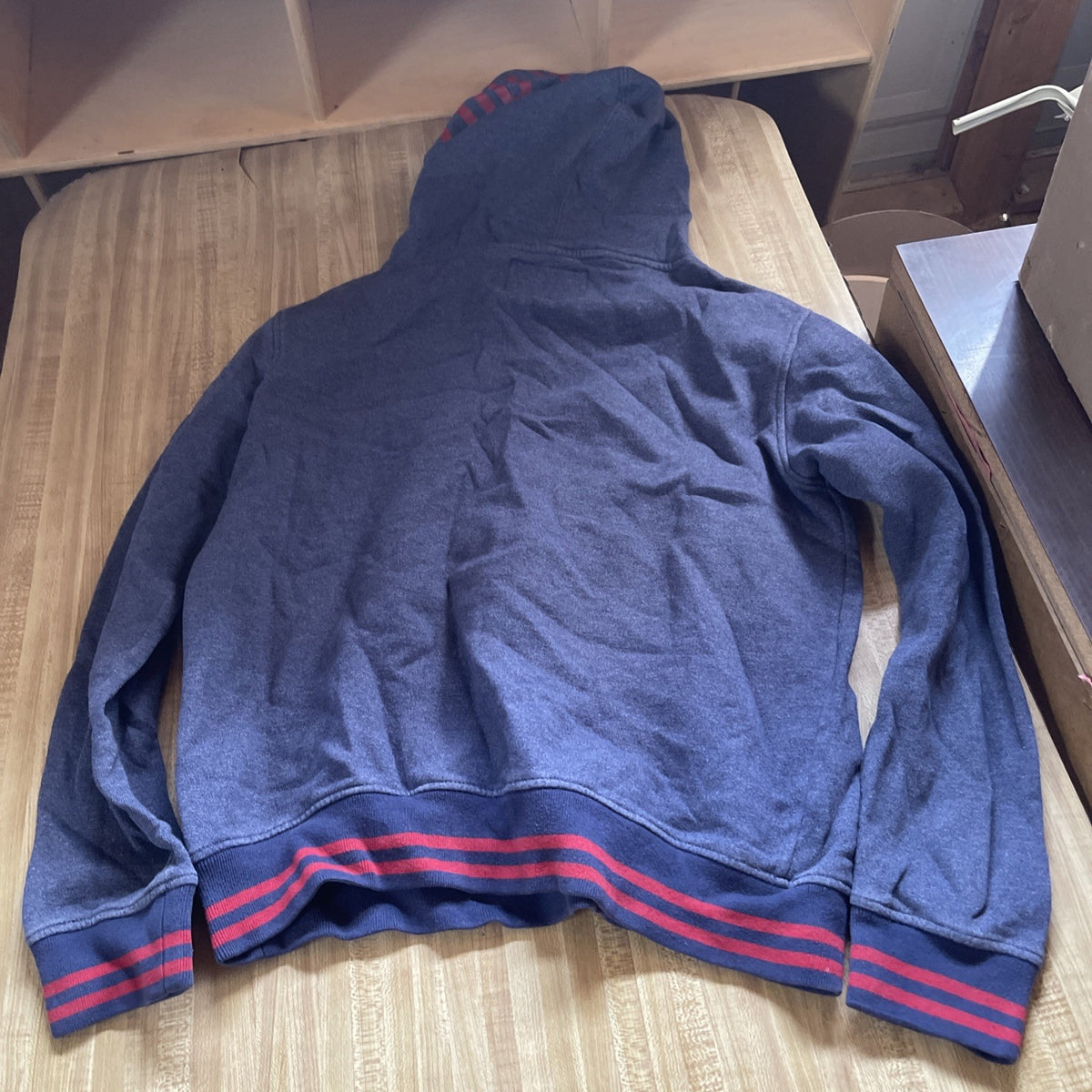 Zoo York Chaz hoodie medium in navy blue with red striped cuffs and waistband laid flat on a wooden surface